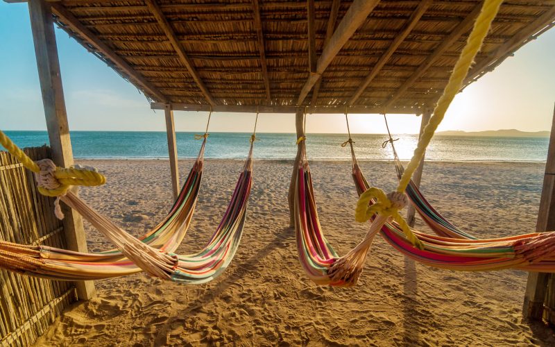 Bright colorful hammocks on the beach at sunset
